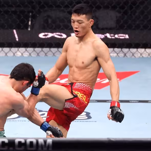 UFC fighter Su Mudaerji delivering a right knee strike to a crouching opponent during an MMA fight